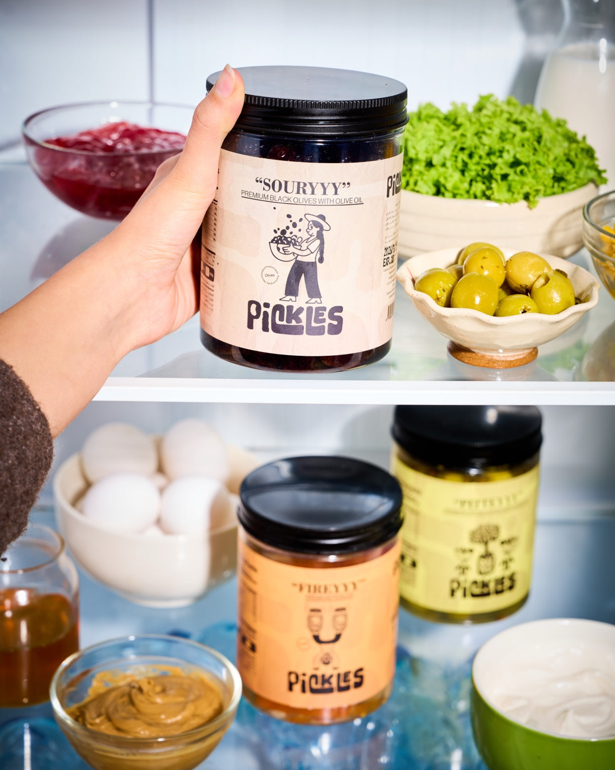 Pickles Souryyy premium black olives inside a refrigerator